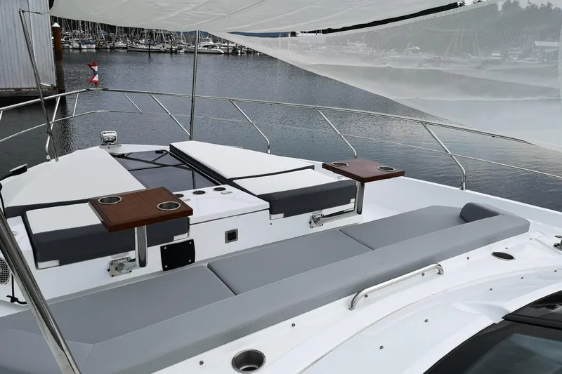  Yacht Photos Pics 2021 Cruisers Yachts 60 Cantius deck with seating and tables, docked at marina.