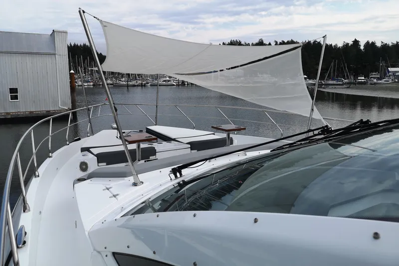  Yacht Photos Pics 2021 Cruisers Yachts 60 Cantius with sunshade, docked in a marina setting.