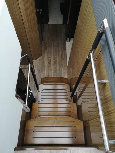  Yacht Photos Pics Staircase inside 2021 Cruisers Yachts 60 Cantius, featuring sleek wooden design.