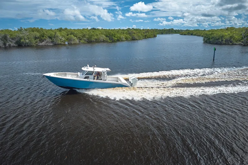 Tropical Moon Yacht Photos Pics 2022 Solace 41 CS boat cruising on a scenic river under a blue sky.