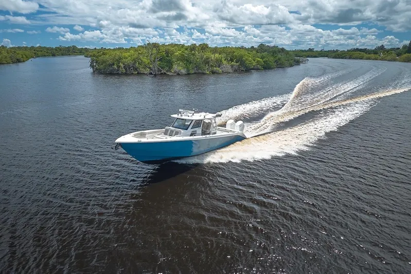 Tropical Moon Yacht Photos Pics 2022 Solace 41 CS boat cruising on a scenic river under a cloudy sky.
