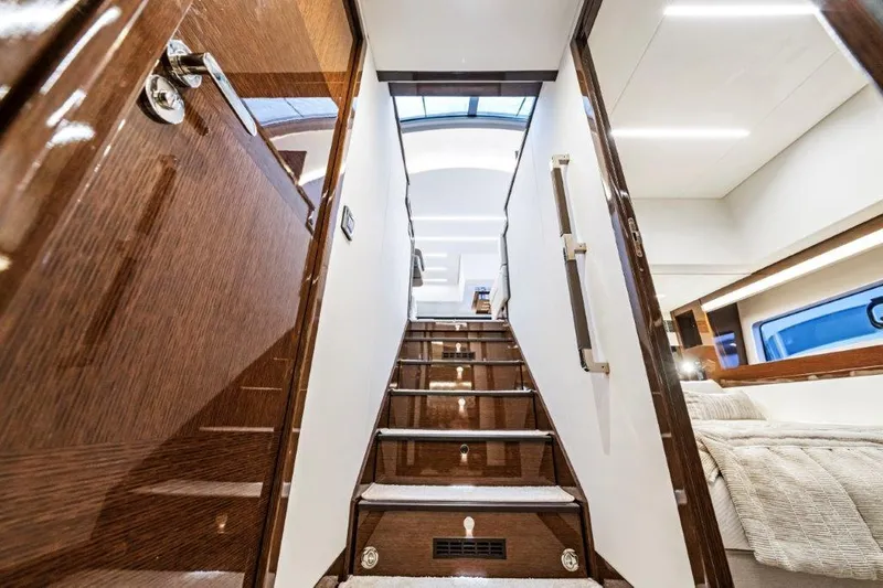 59' 2020 Prestige 590 Flybridge Yacht Photos Pics Luxurious interior of 2020 Prestige 590 flybridge yacht with polished wood staircase.