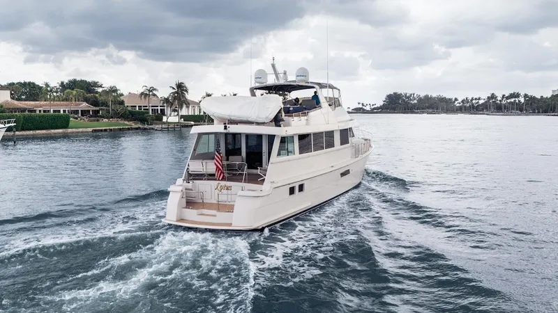  Yacht Photos Pics 1998 Hatteras 74 Sport Deck Motor Yacht cruising on a calm waterway under cloudy skies.