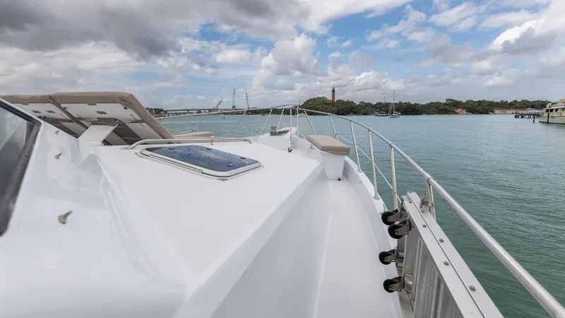  Yacht Photos Pics 1998 Hatteras 74 Sport Deck Motor Yacht on calm waters under a partly cloudy sky.