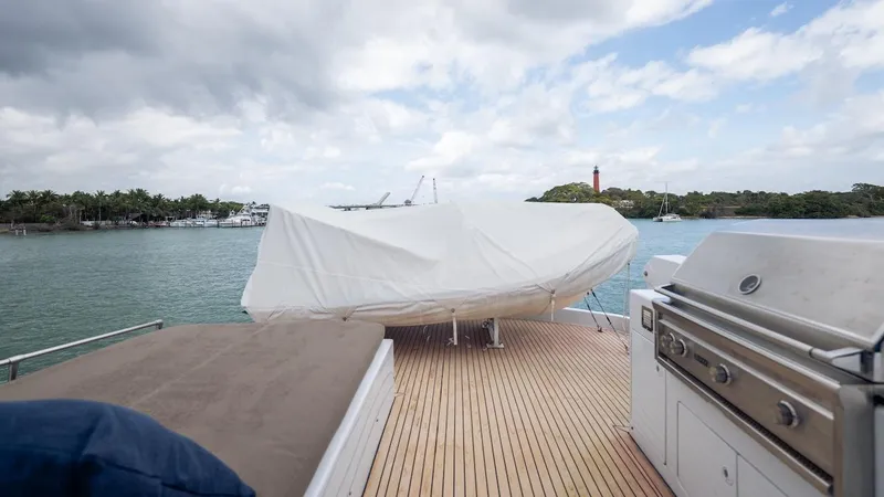  Yacht Photos Pics 1998 Hatteras 74 Sport Deck Motor Yacht with covered deck and grill, overlooking scenic waterway.