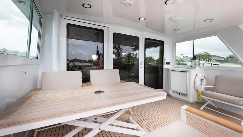  Yacht Photos Pics 1998 Hatteras 74 Sport Deck Motor Yacht interior with seating and table on deck.