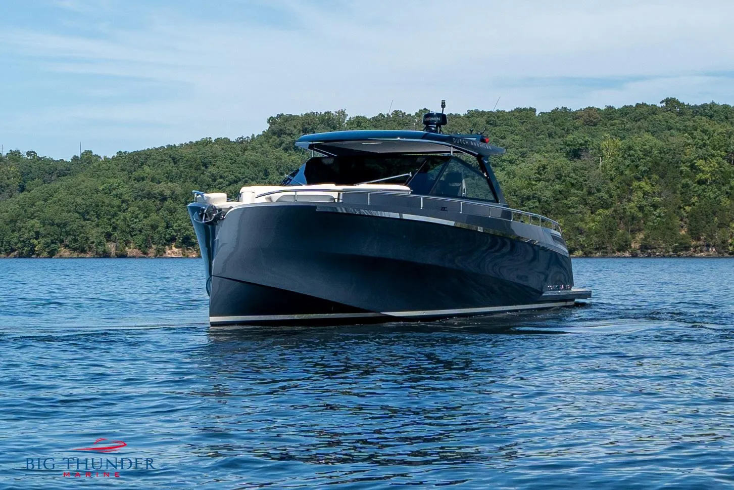 2024 Dutch American Iconic DA 50 yacht on a serene lake with lush green shoreline.