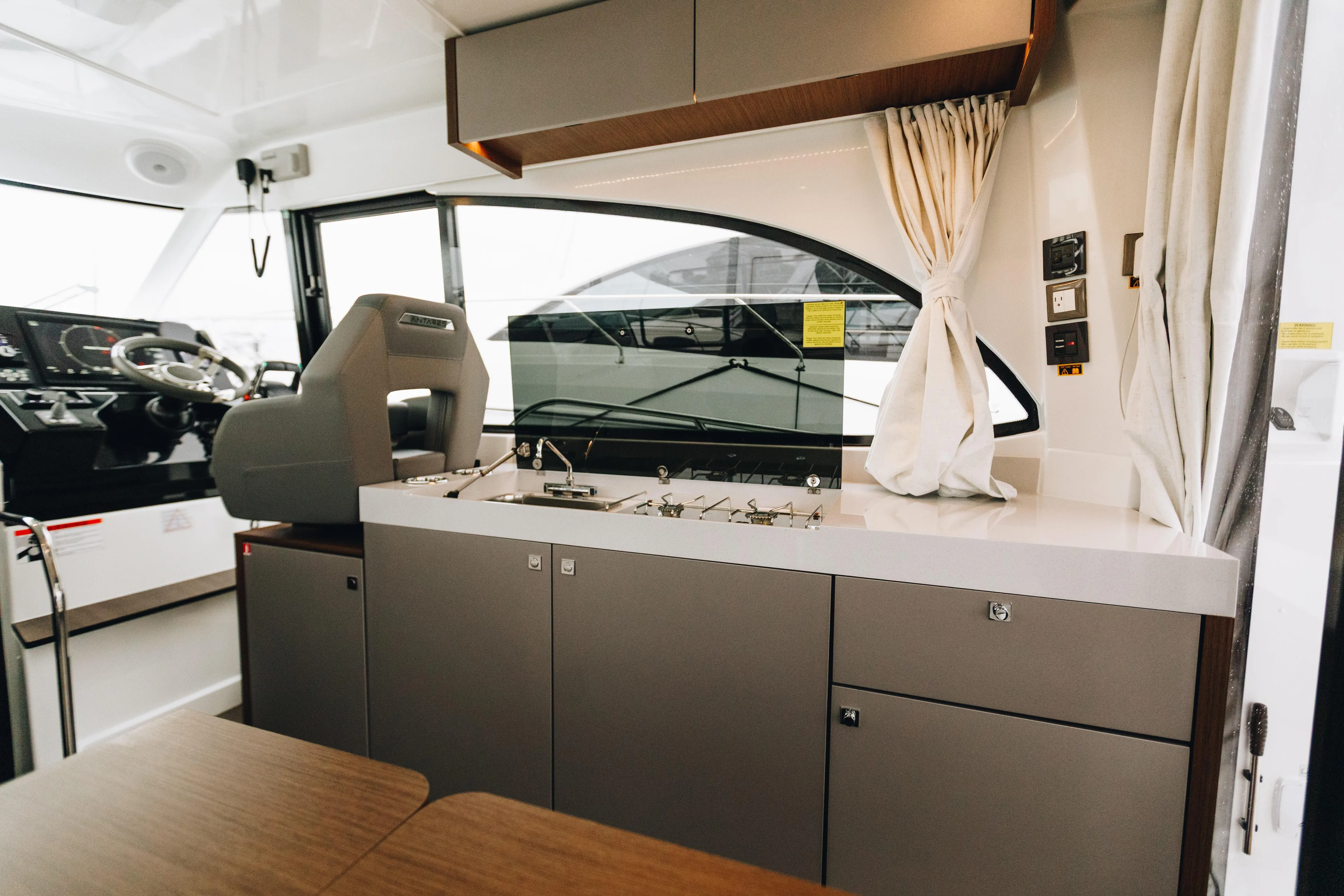  Yacht Photos Pics Interior of 2026 Beneteau Antares 11 Fly yacht, featuring helm and kitchenette.