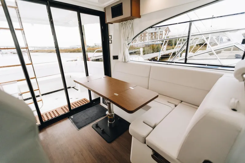  Yacht Photos Pics Luxurious interior of 2026 Beneteau Antares 11 Fly with elegant seating and wooden table.