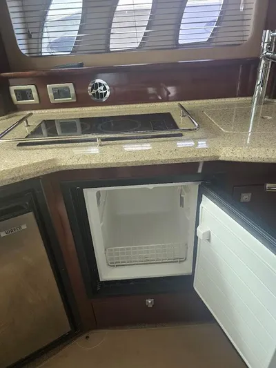  Yacht Photos Pics 2008 Sea Ray 40 Sundancer yacht kitchen with stove, sink, and open mini fridge.