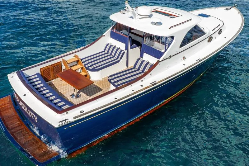 Volatility Yacht Photos Pics Luxury San Juan SJ 38 yacht, 2003 model, with striped seating on blue ocean water.