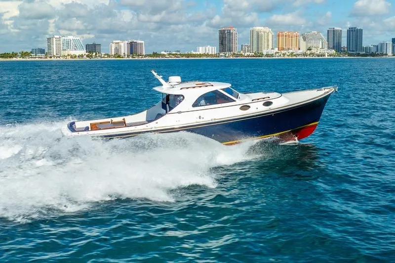 Volatility Yacht Photos Pics San Juan SJ 38 yacht cruising on blue ocean near city skyline, 2003 model.