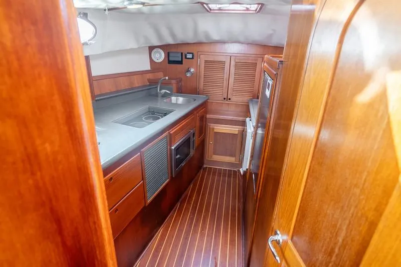 Volatility Yacht Photos Pics 2003 San Juan SJ 38 yacht interior with wooden cabinetry and modern kitchen amenities.