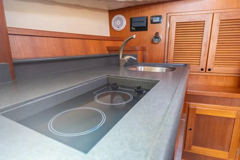 Volatility Yacht Photos Pics 2003 San Juan SJ 38 yacht kitchen with stove, sink, and wooden cabinetry.