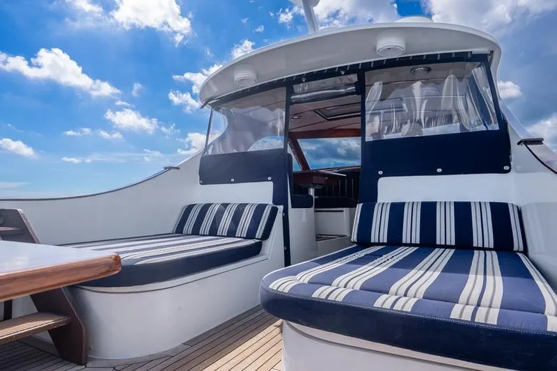 Volatility Yacht Photos Pics Luxurious 2003 San Juan SJ 38 yacht interior with striped seating under a bright blue sky.