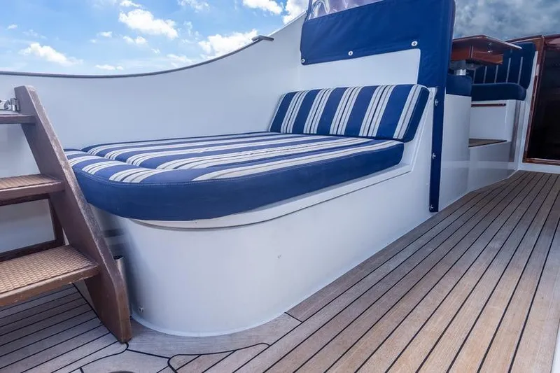 Volatility Yacht Photos Pics Luxury seating area on 2003 San Juan SJ 38 yacht with striped cushions and wooden deck.