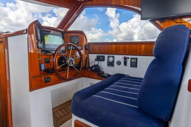 Volatility Yacht Photos Pics Interior of 2003 San Juan SJ 38 boat with wooden helm and blue cushioned seat.