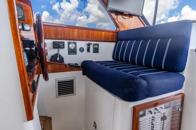 Volatility Yacht Photos Pics Interior of 2003 San Juan SJ 38 boat with blue-striped seating and wooden dashboard.
