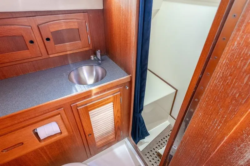 Volatility Yacht Photos Pics 2003 San Juan SJ 38 yacht bathroom with wooden cabinetry and stainless steel sink.