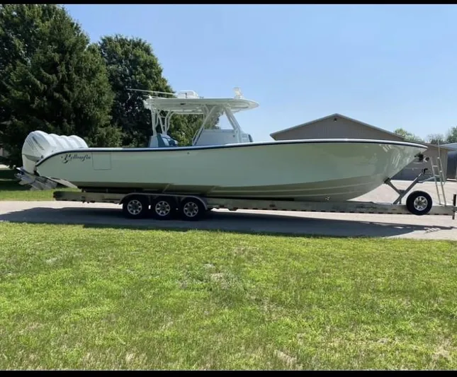  Yacht Photos Pics 2016 Yellowfin 39 boat on trailer, parked on grass, sunny day.