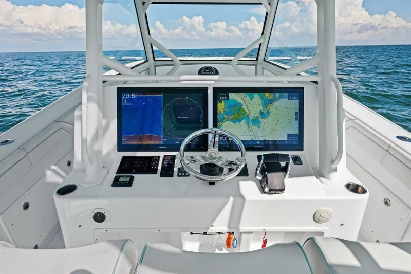 Midnight Rider Yacht Photos Pics 2017 Yellowfin 42 Offshore boat dashboard with navigation screens and steering wheel on open sea.