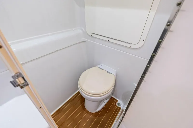Midnight Rider Yacht Photos Pics 2017 Yellowfin 42 Offshore boat bathroom with compact toilet and wooden flooring.