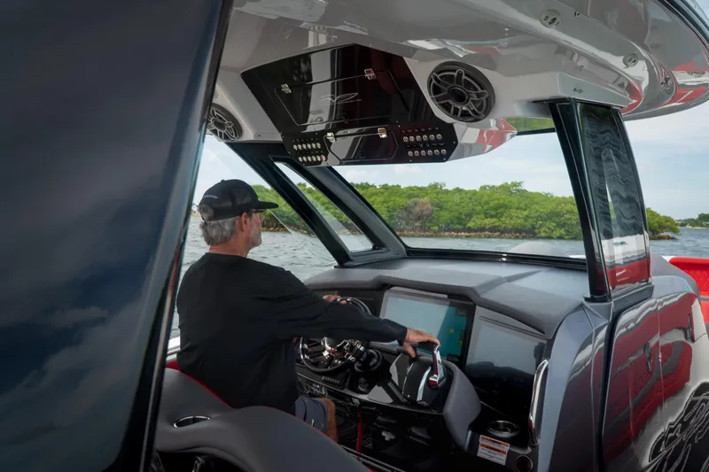  Yacht Photos Pics Man piloting 2024 MTI V42 boat with advanced dashboard technology.