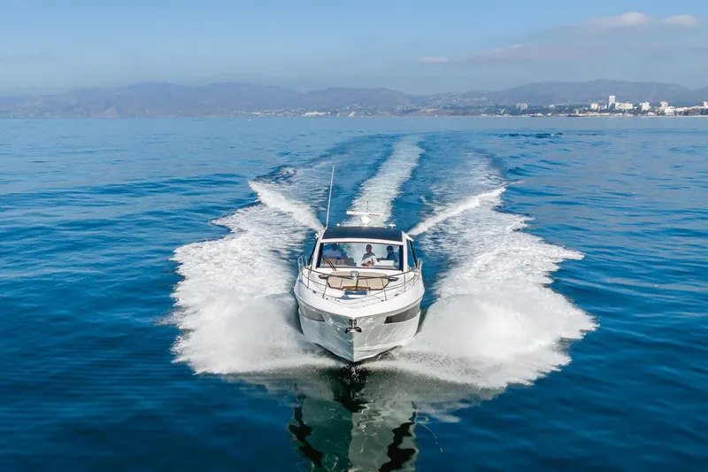 Lux Life Yacht Photos Pics 2017 Cruisers Yachts 39 Express Coupe cruising on open water, scenic coastal backdrop.