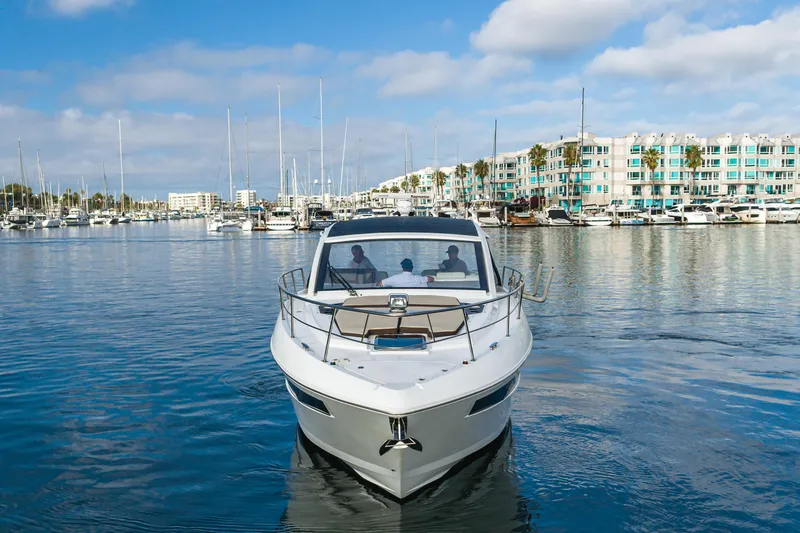 Lux Life Yacht Photos Pics 2017 Cruisers Yachts 39 Express Coupe in marina, clear sky, waterfront buildings.