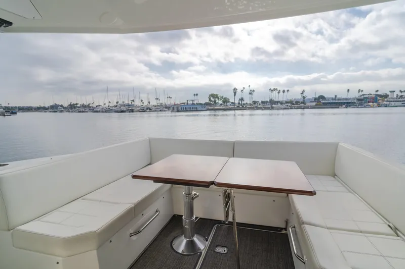 Lux Life Yacht Photos Pics 2017 Cruisers Yachts 39 Express Coupe interior with seating and table, overlooking marina.