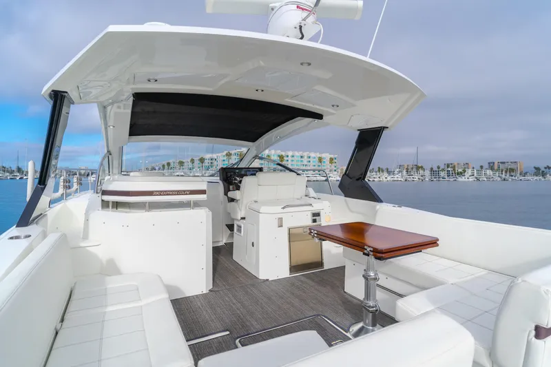Lux Life Yacht Photos Pics 2017 Cruisers Yachts 39 Express Coupe interior with seating and table, docked at marina.