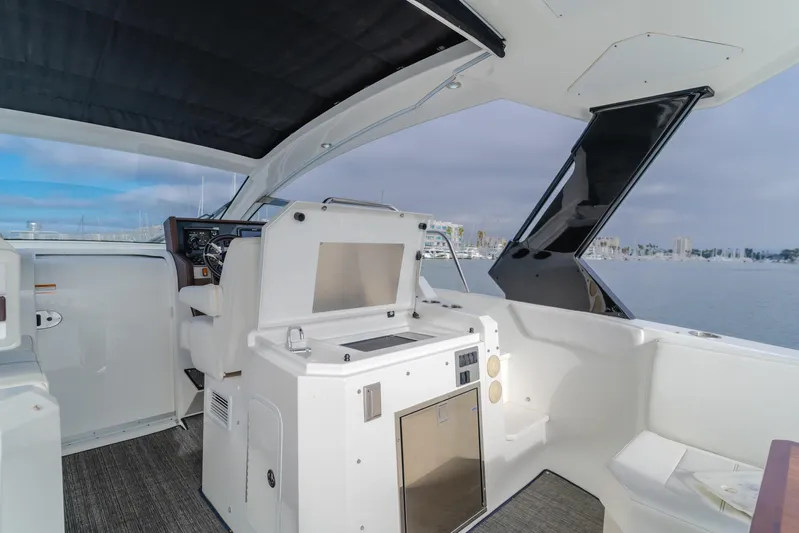 Lux Life Yacht Photos Pics 2017 Cruisers Yachts 39 Express Coupe interior with helm and seating, overlooking marina.