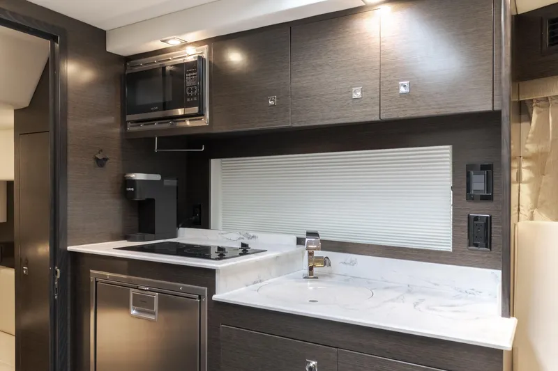 Lux Life Yacht Photos Pics 2017 Cruisers Yachts 39 Express Coupe kitchen with modern appliances and sleek cabinetry.