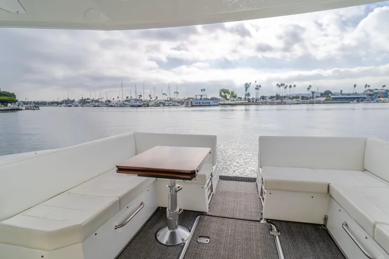 Lux Life Yacht Photos Pics 2017 Cruisers Yachts 39 Express Coupe interior with waterfront view, featuring white seating and table.