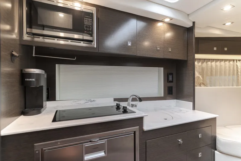 Lux Life Yacht Photos Pics 2017 Cruisers Yachts 39 Express Coupe kitchen with modern appliances and sleek cabinetry.