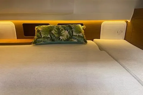  Yacht Photos Pics Cozy cabin interior of 2019 Jeanneau 9.0 WA with tropical-themed pillow.