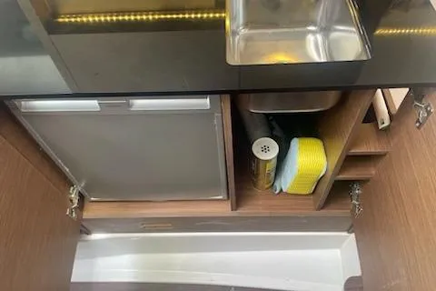  Yacht Photos Pics Compact kitchen area in a 2019 Jeanneau 9.0 WA boat with sink and storage.