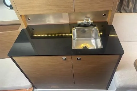  Yacht Photos Pics 2019 Jeanneau 9.0 WA boat interior with sleek kitchenette and stainless steel sink.