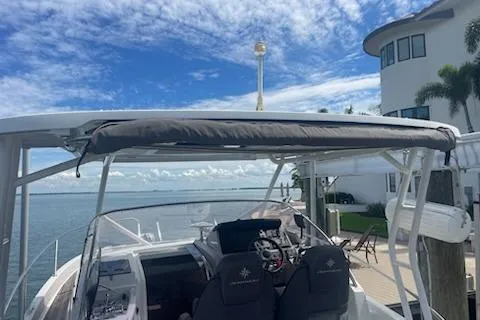  Yacht Photos Pics 2019 Jeanneau 9.0 WA boat docked by waterfront home under blue sky.