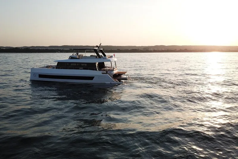  Yacht Photos Pics 2026 Moon Yachts 6ty sailing at sunset on calm waters.