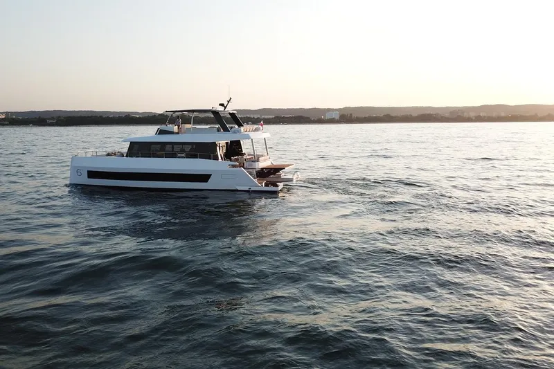  Yacht Photos Pics Luxury Moon Yachts 6ty 2026 sailing at sunset on calm waters.