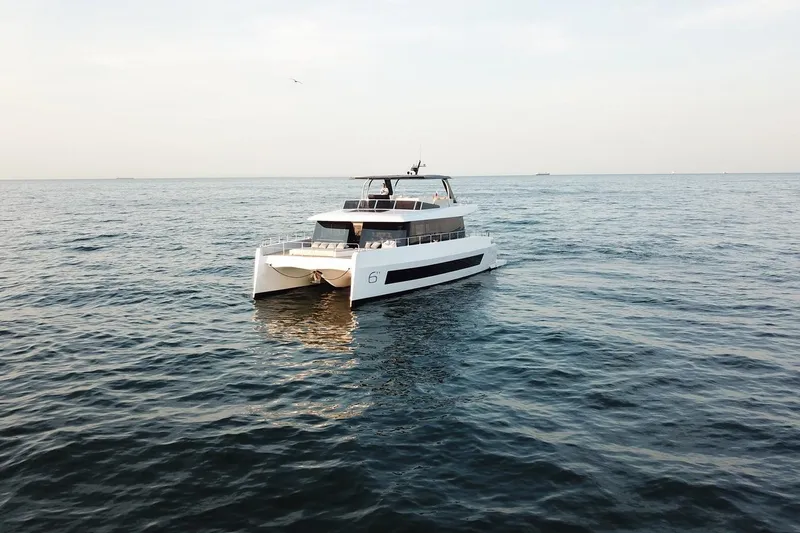  Yacht Photos Pics 2026 Moon Yachts 6ty catamaran cruising on open sea under clear sky.