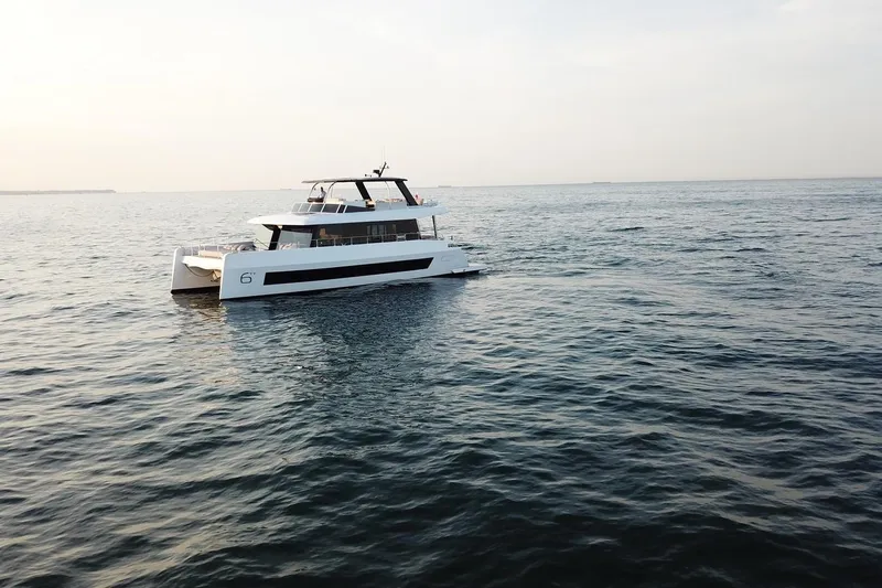  Yacht Photos Pics 2026 Moon Yachts 6ty sailing on calm ocean waters at sunset.