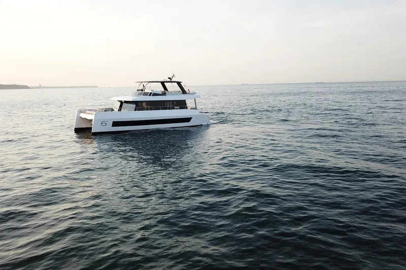  Yacht Photos Pics 2026 Moon Yachts 6ty sailing on calm ocean waters at sunset.