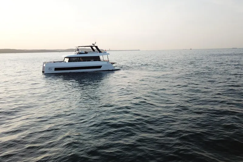  Yacht Photos Pics 2026 Moon Yachts 6ty sailing on calm waters at sunset.