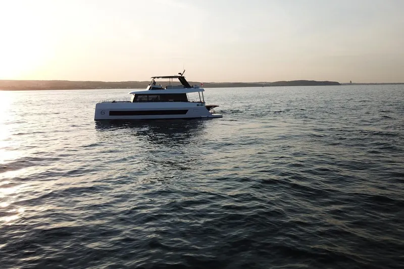  Yacht Photos Pics 2026 Moon Yachts 6ty sailing at sunset on calm waters.