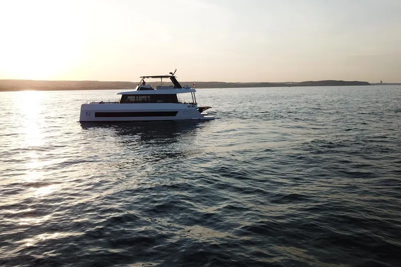  Yacht Photos Pics 2026 Moon Yachts 6ty sailing at sunset on calm waters.