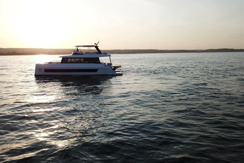  Yacht Photos Pics Moon Yachts 6ty 2026 sailing at sunset on calm waters.