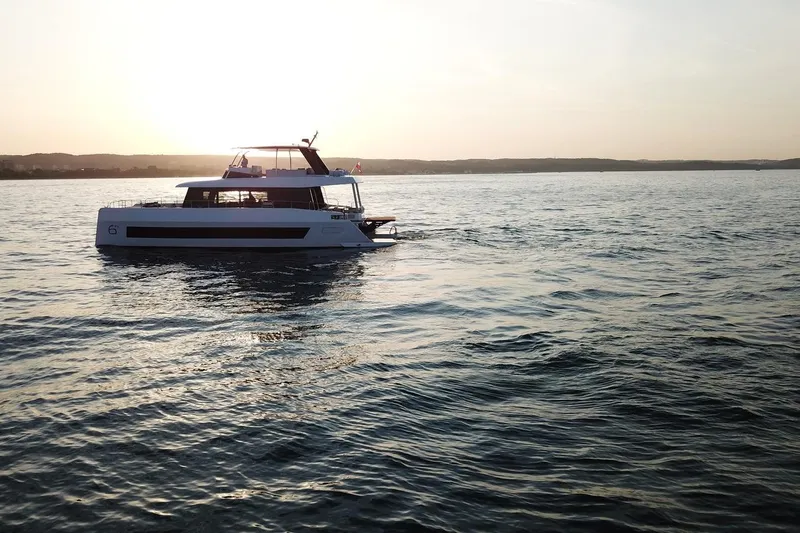  Yacht Photos Pics 2026 Moon Yachts 6ty sailing at sunset on calm waters.