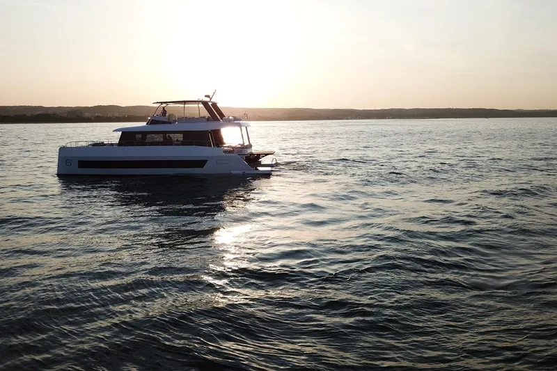  Yacht Photos Pics 2026 Moon Yachts 6ty sailing at sunset on calm waters.